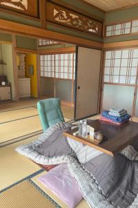 a room with a table and a chair and a rug at 自宅民泊The 34Sassysサッシーズ萩市佐々並 in Yamaguchi