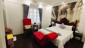 a bedroom with a large bed and a red chair at Khách sạn Đặng Anh in Hanoi +3 photos
