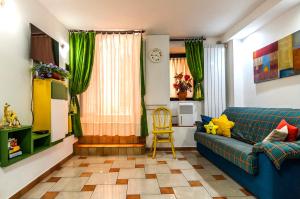- un salon avec un canapé bleu et une chaise dans l'établissement Appartamento Le Riggiole, à Gaète