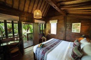 a bedroom with a bed in a room with wooden walls at Kayu Village in Canggu +39 photos
