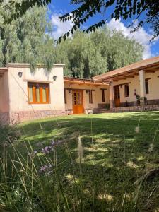 a house with orange doors in a yard at Capec Alojamiento in Tilcara