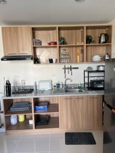a kitchen with wooden cabinets and a sink at Mactan Plains condo unit in Punta Engaño
