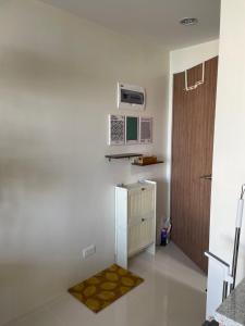 a small kitchen with a refrigerator and a rug at Mactan Plains condo unit in Punta Engaño