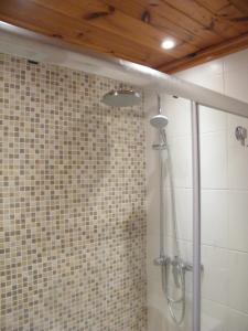 a shower in a bathroom with a tile wall at Nocturne Family House in Paola