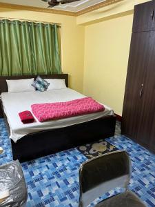 a bedroom with a bed and a chair at PlatinumIN Guesthouse in kolkata
