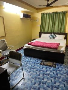 a bedroom with a bed and a chair in it at PlatinumIN Guesthouse in kolkata