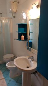 a bathroom with a sink and a toilet and a mirror at Villa Bella Vista in Castellabate