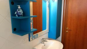 a bathroom with a blue shelf above a sink at Villa Bella Vista in Castellabate