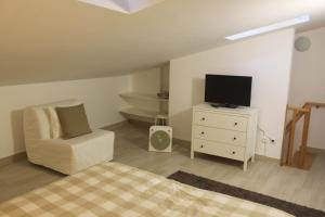 a bedroom with a bed and a tv and a chair at Isaura Home in Peniche