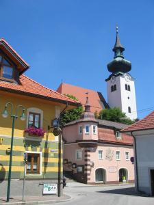 un edificio con una torre dell'orologio sopra di Gasthof zur Post a Schörfling am Attersee