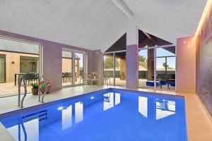 a large swimming pool with blue water in a house at Feriehus 1147 in Ringkøbing