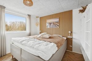 a bedroom with a large bed and a window at Feriehus 1147 in Ringkøbing +26 photos
