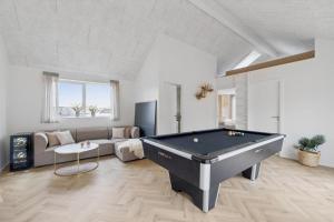 a living room with a pool table and a couch at Feriehus 1147 in Ringkøbing