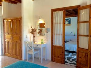 a room with a desk and a bedroom with a bed at Manos Studios in Platis Gialos