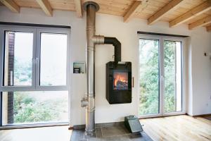 a fireplace in a living room with windows at Basalt-Loft in Kottenheim