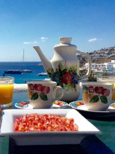 een tafel met een bord eten en een theepot en kopjes bij Manos Studios in Platis Yialos Mykonos