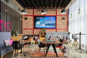 a restaurant with tables and chairs and a brick wall at Moxy Katowice Airport in Pyrzowice +42 photos