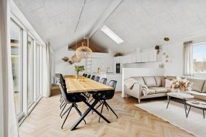 a dining room and living room with a table and chairs at Feriehus 1147 in Ringkøbing