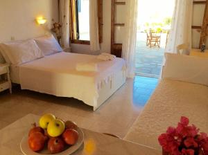 a bedroom with a bed and a plate of fruit on a table at Manos Studios in Platis Gialos