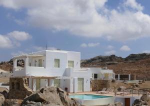 a white house with a swimming pool in the desert at Villas Naxos Grande Vista in Vívlos