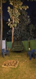 a park with a bench and two blue stools at Nishatana Farm Stay in Bangalore