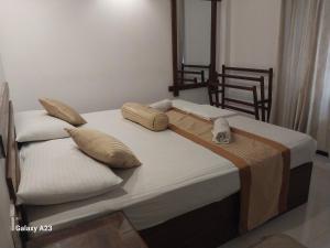 a bed with two pillows on top of it at Sadula Holiday Resort in Anuradhapura +44 photos