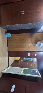 a kitchen with wooden cabinets and a glass counter top at Nishatana Farm Stay in Bangalore
