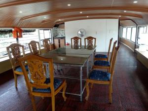 een eetkamer met een tafel en stoelen bij Kerala Nature Houseboat by Coco floatel in Alleppey