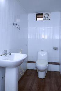 een witte badkamer met een wastafel en een toilet bij Kerala Nature Houseboat by Coco floatel in Alleppey +21 foto's