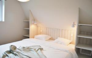 a bedroom with two beds with white sheets and shelves at Vakantiehuis Hof te Voorde in Deerlijk