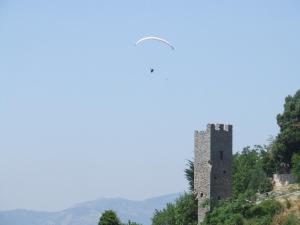 een kasteel op een heuvel met een vogel die er overheen vliegt bij Apartment De Gasperi in Serrone