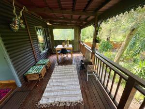 a porch of a cabin with a table and a desk at Elephant loft in Stormsrivier