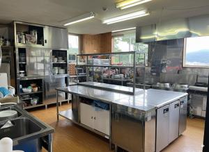 a kitchen with stainless steel appliances in a kitchen at Kamoshika Lodge Hakuba in Minami Otari +19 photos