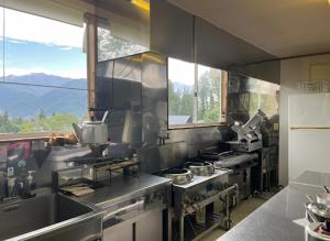 a kitchen with stainless steel appliances in a kitchen at Kamoshika Lodge Hakuba in Minami Otari