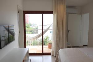 een slaapkamer met een bed en een glazen schuifdeur bij Casa Aia in Aracaju +8 foto's