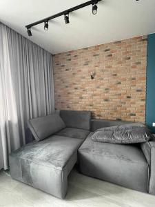a living room with a couch and a brick wall at Sky City room in Odesa