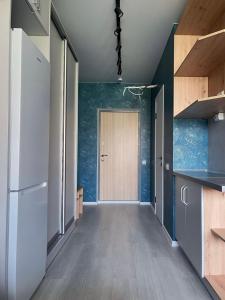 an empty room with a door and a hallway with a kitchen at Sky City room in Odesa