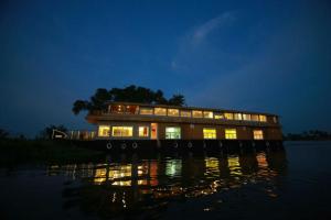 een huis op een boot in het water 's nachts bij Kerala Nature Houseboat by Coco floatel in Alleppey