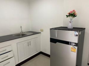 a kitchen with a refrigerator and a sink with a vase of flowers at Chiang Mai view place in Ban Hua Phrong