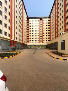 een lege parkeerplaats met gebouwen op de achtergrond bij Nzuri Apartment in Kisumu