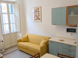 a living room with a yellow couch in a kitchen at Grottammare mon amour Ponente in Grottammare