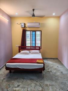 una camera da letto con un letto e una finestra di Villa Bonny Home Stay a Pondicherry