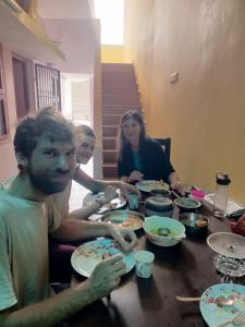 un gruppo di persone sedute a un tavolo che mangiano cibo di Villa Bonny Home Stay a Pondicherry
