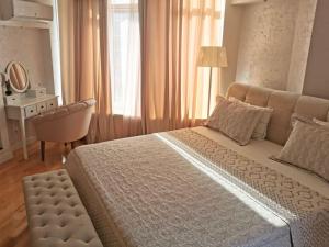 una camera da letto con un letto grande e una scrivania di Stunning design apartment with Jacuzzi a Chişinău