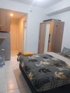 a bedroom with a bed with a black and yellow blanket at Asikin Room in Bulanbulan