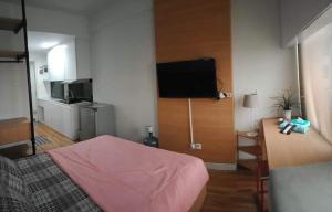 a bedroom with a bed and a flat screen tv at Asikin Room in Bulanbulan