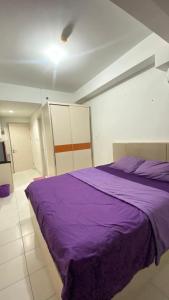 a bedroom with a purple bed in a room at Asikin Room in Bulanbulan