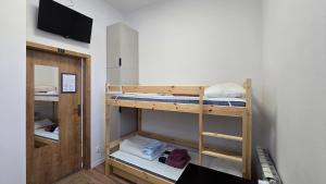 een kamer met 2 stapelbedden en een flatscreen-tv bij Mini nocleg przy dworcu in Tomaszów Mazowiecki