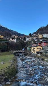 a river in a town with buildings and houses at Appartamento Verdenatura in Branzi