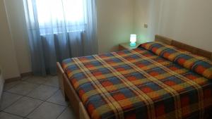 a bedroom with a bed with a colorful blanket at Villa Bella Vista in Castellabate